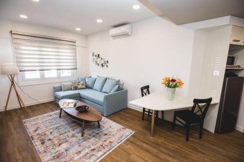 a living room with a blue couch and a table at Gaspar Apartment - 4th floor - Renovated 2019 in Athens