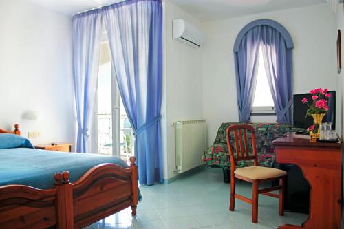 1 dormitorio con cama, escritorio y silla en La Pergola del Torchio en Isquia