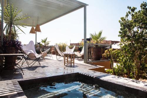 patio con tavolo e sedie e piscina. di Riad Danka a Marrakech
