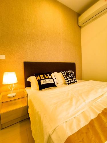 a bedroom with a bed with pillows and a lamp at Legoland D'PRISTINE Apartment By TGP in Nusajaya