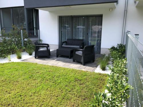 eine Terrasse mit einem Sofa und einem Stuhl auf einem Haus in der Unterkunft Apartament 33BalticBlue in Pogorzelica