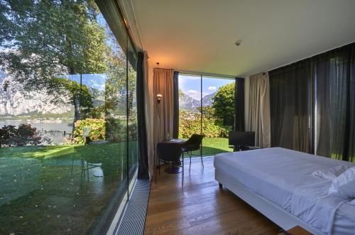 a bedroom with a bed and a large glass window at Casa Sull'Albero in Malgrate