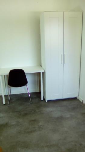 studio évasion في Éterville: غرفة فارغة بها مكتب وكرسي