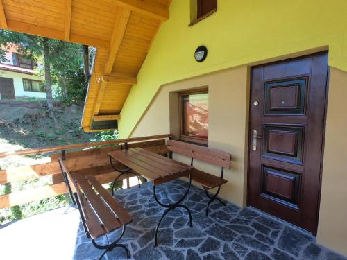 a porch with a bench and a wooden door at Ośrodek Wczasowy Wierchy in Korbielów