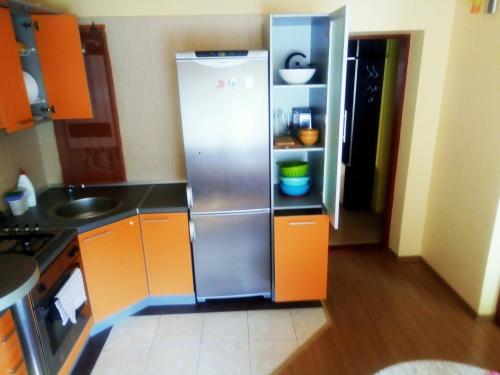 a small kitchen with a stainless steel refrigerator at Šeimos apartamentai Maironio gatveje in Palanga