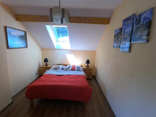 a bedroom with a bed with a red blanket at Ośrodek Wczasowy Wierchy in Korbielów