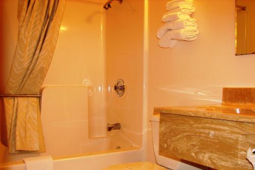 uma casa de banho com um chuveiro, um WC e um lavatório. em Baxter Inn 4 Less em Baxter Springs
