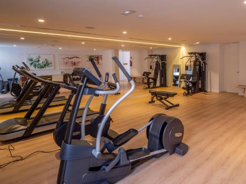 a gym with treadmills and exercise equipment in a building at Ca Na Xica - Hotel & Spa in Sant Miquel de Balansat