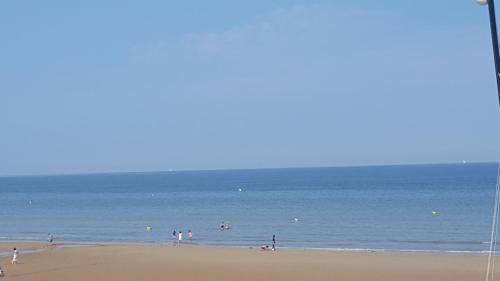 a group of people playing in the water at the beach at Plage Cabourg 7bis in Cabourg