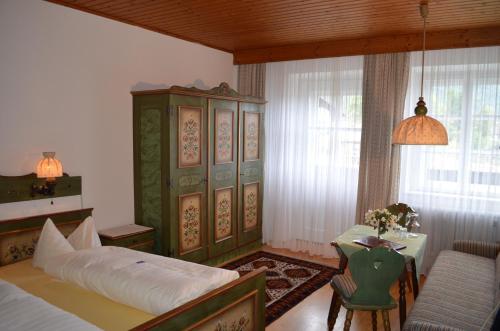 a bedroom with a bed and a table and a chair at "Kaiser Karl" *** Ferienwohnungen in Grossgmain