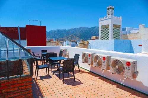 a balcony with chairs and tables on a roof at Dar Fama in Tétouan