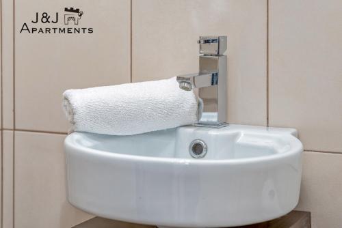 a bathroom sink with a roll of toilet paper on it at J&J Apartments, Szczytna 1, Apartament 9 in Toruń