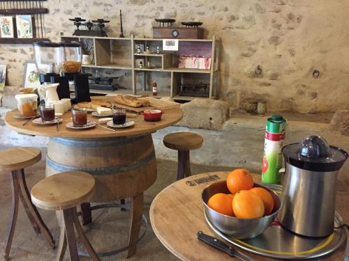 una cocina con mesa y un tazón de naranjas en Le Mas de la Roche, en Montbrison-sur-Lez
