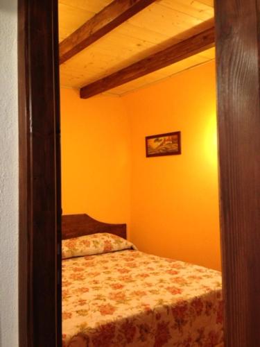 Il Borgo 19 في Scapoli: غرفة نوم بسرير في غرفة صفراء