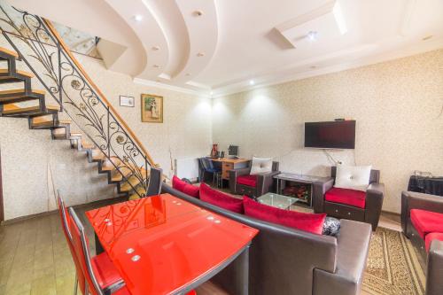 a living room with a staircase and red chairs at Old Gate Inn in Akhaltsikhe