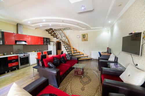 a living room with a red couch and a staircase at Old Gate Inn in Akhaltsikhe