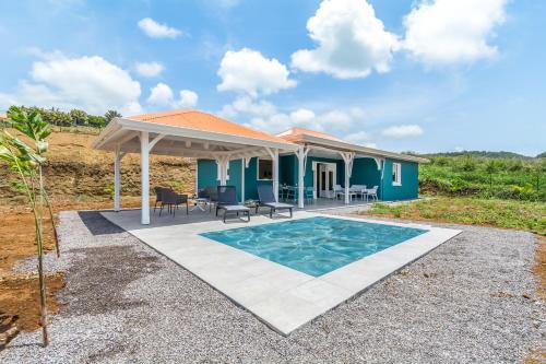 Cette maison bleue dispose d'une terrasse et d'une piscine. dans l'établissement Sealake Villas, au Vauclin