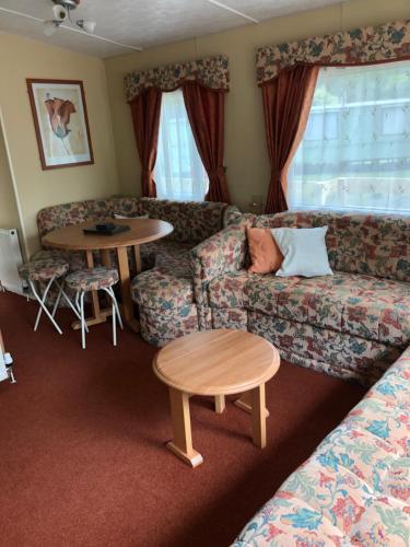 a living room with a couch and a table at 62 Glenfinart Caravan Park in Dunoon