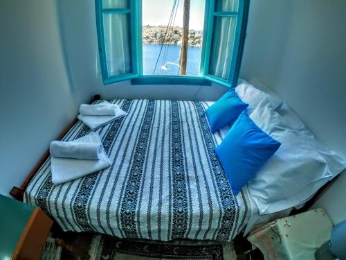 a small bed in a room with a window at Villa Pitini in Symi