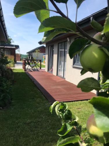 a wooden deck in front of a house at Domki Wśród Jabłoni in Gąski