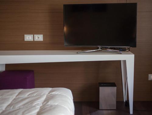 a flat screen tv sitting on top of a bed at Relais Metelli in Foligno
