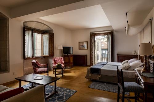 a bedroom with a bed and a living room at Parador de Pontevedra in Pontevedra