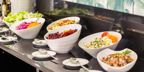 a buffet line with bowls of different types of food at Aurea Fatima Hotel Congress & Spa in Fátima