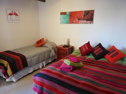 a bedroom with a bed, a desk, and a lamp at Anka Hostel in San Pedro de Atacama