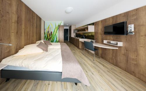 a bedroom with a bed and a desk and a tv at Boarding & HOUSE T24 in Bad Wurzach