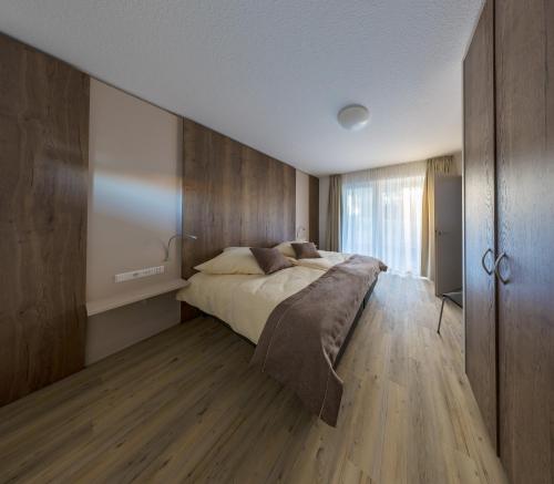 a bedroom with a large bed and wooden walls at Boarding & HOUSE T24 in Bad Wurzach