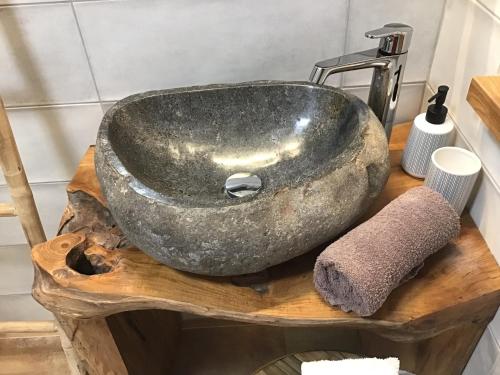 a stone sink on a wooden counter in a bathroom at Apartmány Sebastian in Mikulov