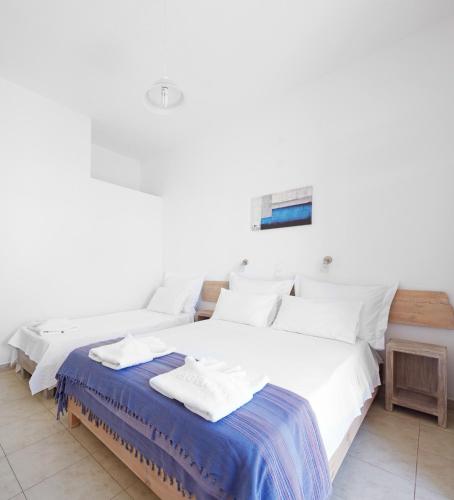 two beds in a room with white walls at Londos Hotel in Piso Livadi