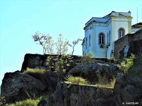 a building sitting on top of a rocky hill at AL Ribeirinho in Mértola