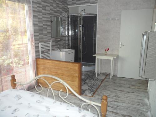 une chambre avec un lit et une salle de bain avec douche dans l'établissement ô bout d'la Motte, à Voillecomte