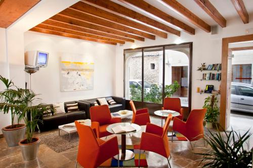 a living room with red chairs and a couch at L'Host Boutique Rooms in Pollença