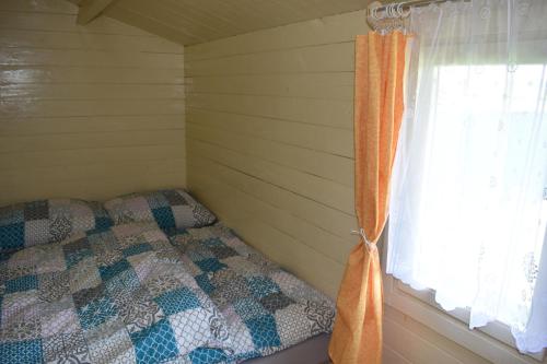 a bedroom with a bed next to a window at Chata 1 in Nový Přerov
