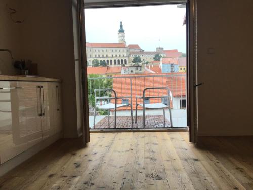 an open door to a balcony with a view of a building at Apartmány Sebastian in Mikulov