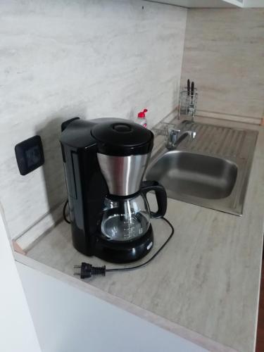 a coffee maker sitting on a counter next to a sink at Fortuna Apartments in Bansko