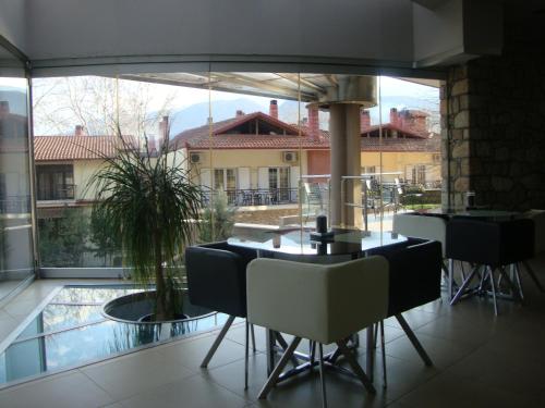 a room with a table and chairs and a large window at Nymfes Hotel in Kato Loutraki
