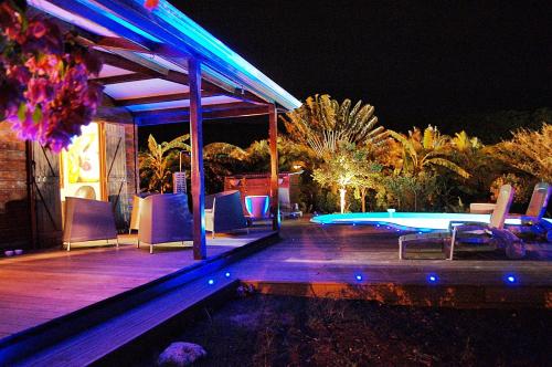 een patio met een zwembad en een tafel en stoelen bij Villa Tara Fort Royal in Deshaies