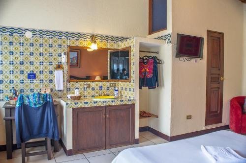 cocina con fregadero y espejo en Hotel Casa del Parque by AHS, en Antigua Guatemala