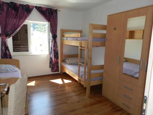 a room with bunk beds with a window and a door at Apartmani Maruncic in Omiš