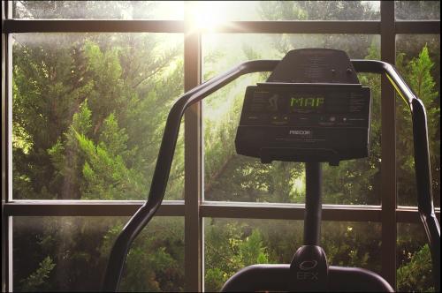 a clock on a treadmill in front of a window at Hotel Victoria Express in Durango