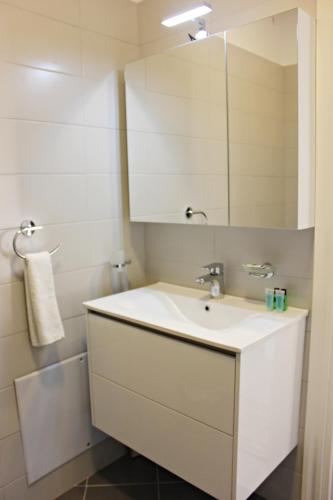 a bathroom with a white sink and a mirror at Erin Luxury Home in Sarandë