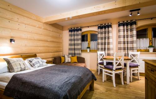 a bedroom with a bed and a table and chairs at Apartamenty Pod Giewontem in Zakopane
