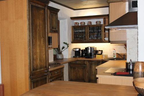 cocina con armarios de madera y encimera en Krapi Guesthouse, en Treimani