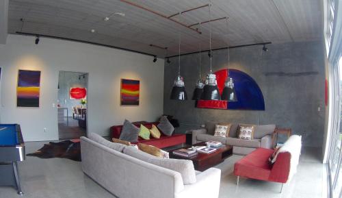 a living room with two couches and a table at Te Whara at Kauri Mountain Point in Whangarei