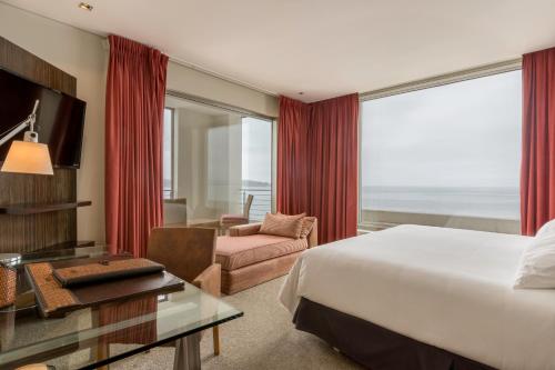 a hotel room with a bed and a view of the ocean at Enjoy Coquimbo in Coquimbo
