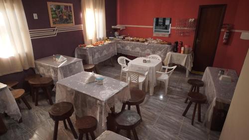 a restaurant with white tables and chairs and a counter at Pousada Centaurus in Alto Paraíso de Goiás