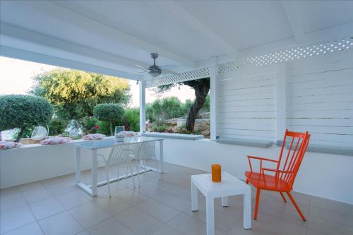 a white patio with a table and two chairs at Mareggio Exclusive Residences & Suites in Gythio